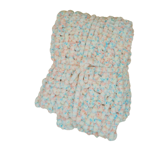 A chunky knit blanket made from variegated chenille yarn in pastel pink, light blue, and off-white, folded neatly on a solid white background.